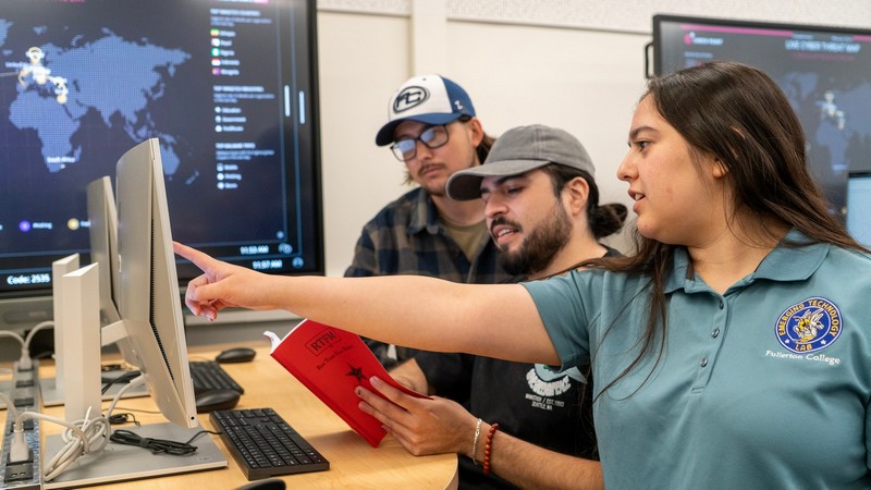 Students with instructor pointing at computer screen